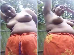 Chubby Indian woman from a small village puts on her clothes after a nice outdoor bathing