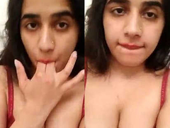 Horny Desi girl sucking on her nipples while showing her cleavage in XXX style