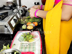Desi woman is in the kitchen and she wears a saree while talking about some XXX